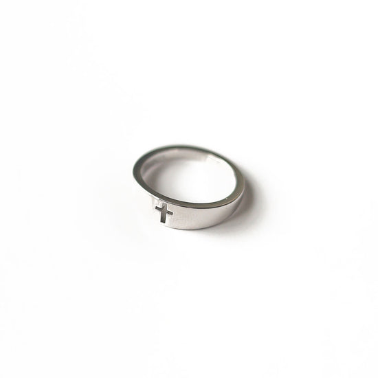 A close-up image of a stunning Cross Ring Silver. The ring is crafted from sterling silver and features an intricately etched cross design. The image showcases the exquisite craftsmanship and elegant details of the ring, capturing its timeless beauty and spiritual significance.