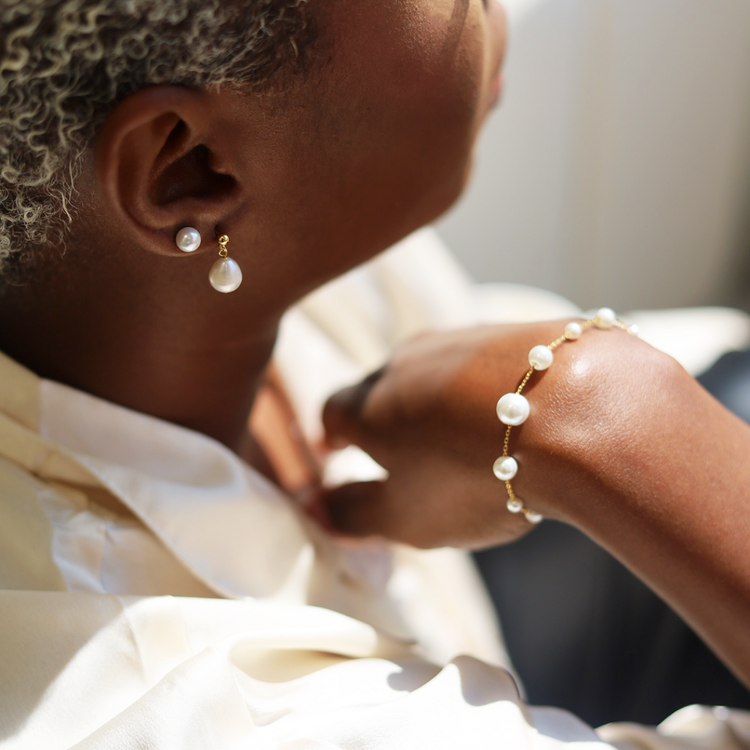 Woman wearing pearl bracelet and earrings