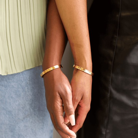 Two women wearing cuff bracelets