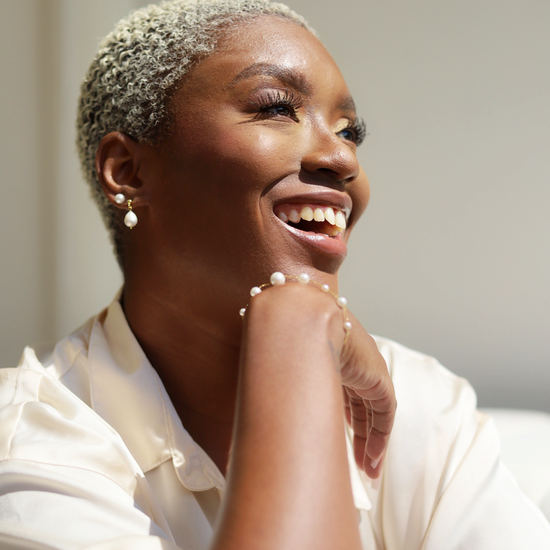 Woman smiling while wearing pearls from Jewmei